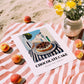 Chocolate Cake – White village Street Café Scene, American Dessert Print, unframed on coastal sand