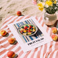Fruit Salad – on Striped Tablecloth, American Food Still Life, unframed on coastal sand