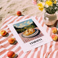 Ciabatta – Hilltop Café Scene, Italian Pastry Illustration, unframed on coastal sand